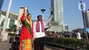 Abang None Jakarta melakukan tarian lenggang Jakarta saat sosialisasi pemilihan Abang None Jakarta 2025 di sekitar kawasan Bundaran Hotel Indonesia, Jakarta, Minggu (8/6/2025). (Liputan6.com/Angga Yuniar)
