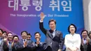 Presiden Korea Selatan Lee Jae-myung (mengangkat tangan) bersama istrinya Kim Hye-kyung saat bersiap untuk meninggalkan tempat setelah upacara pelantikan di Majelis Nasional di Seoul pada 4 Juni 2025. (Lee Jin-man/POOL/AFP)