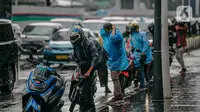 Pengendara motor menggunakan jas hujan saat hujan deras mengguyur kawasan Jalan Thamrin, Jakarta, Selasa (31/5/2022). Potensi cuaca ekstrem di sejumlah wilayah di Indonesia pada hari ini dipengaruhi oleh kemunculan bibit siklon tropis 92S di Samudera Hindia selatan Jawa Barat. (Liputan6.com/Faizal Fanani)