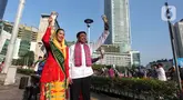 Abang None Jakarta melakukan tarian lenggang Jakarta saat sosialisasi pemilihan Abang None Jakarta 2025 di sekitar kawasan Bundaran Hotel Indonesia, Jakarta, Minggu (8/6/2025). (Liputan6.com/Angga Yuniar)