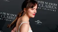Aktris Dakota Johnson berpose saat menghadiri penayangan perdana film terbarunya, Fifty Shades Freed di Salle Pleyel di Paris, Prancis (6/2). Aktris 28 tahun ini tampil cantik dan seksi dengan gaun putih yang dikenakannnya. (AP Photo/Francois Mori)